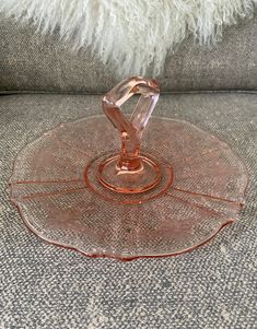 an empty glass plate sitting on top of a couch