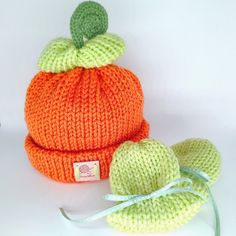 an orange knitted pumpkin hat and booties with a green leaf on the top