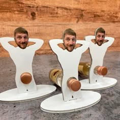 three cardboard cutouts of two men, one with his head in the shape of a bottle