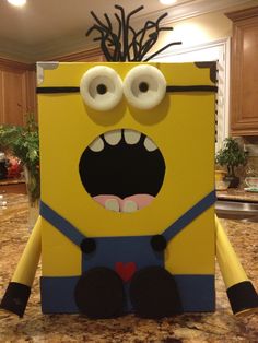 a cardboard box that looks like a minion with googly eyes