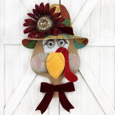 a turkey wearing a hat with a flower on it's head hanging from a barn door