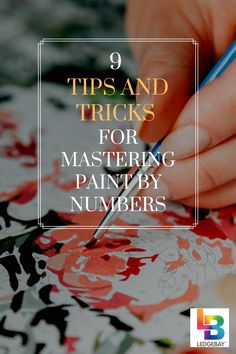 a woman's hand with a pen writing on paper and the words 9 tips and tricks for mastering painting by numbers