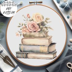 a cross stitch pattern with books and flowers on it, surrounded by yarns and scissors