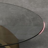 a glass table with a metal base and red light coming from the top, on a gray background