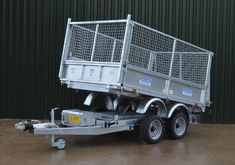 a trailer with caged sides parked in front of a building