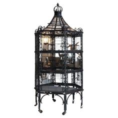 a black birdcage sitting on top of a table next to a light fixture