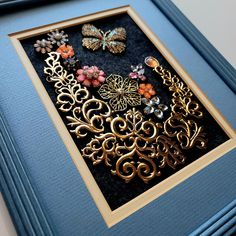 there are many different types of brooches in the frame on this table top