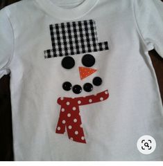 a white shirt with a snowman on it's chest and polka dots around the neck