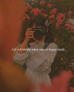 a woman taking a photo with her camera in front of pink flowers and the words life is beautiful when you are happy inside