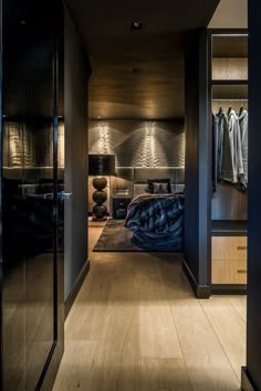 an open door leading to a bedroom with clothes hanging on the walls and closets