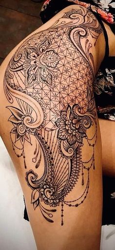 a woman's thigh with an intricate tattoo on it