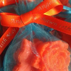 orange roses wrapped in blue mesh bags with name tags on the handles and ribbon around them