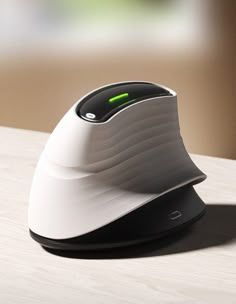 a computer mouse sitting on top of a wooden table with a green light in the middle