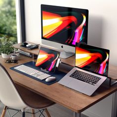 two laptops and a desktop computer on a wooden desk in front of a window