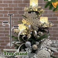 a christmas tree with candles and ornaments on it in front of a brick wall that reads, christmas tree stand