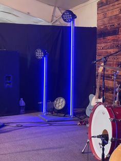 two guitars are sitting on the floor in front of some speakers and other musical equipment