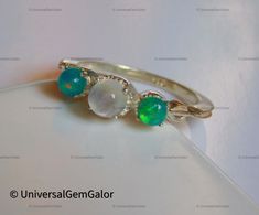 Genuine Opal and Moonstone Ring* Moonstone Garland Ring* Three Stone Ring* Green Opal Ring* Vintage Silver Moonstone Opal Ring*Gifts For Her if you would prefer a custom ring, please contact us. Stone - Ethiopian Opal and Rainbow Moonstone Stone Size - Moonstone round 5mm and opal round green 4mm Metal - 925 Sterling Silver with 14k Gold Plating 100% Genuine & Natural Measurements and weight are close to approximations ---------------------------------------------------------------------------------------------------- About US: ---------------------------------------------------------------------------------------------------- UniversalGemGalor based in New York, USA is a company engaged in supplier, manufacturing, wholesale and retail business of Gemstones ( semi precious stones and preci Garland Ring, Opal Ring Vintage, Ring Three Stone, Ring Moonstone, Moonstone Stone, Three Stone Ring, Green Opal, Custom Ring, Three Stone Rings