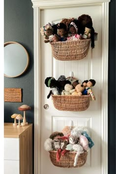 two baskets filled with stuffed animals hanging on a door