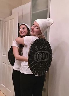 two girls hugging each other in front of a door with the word oreo on it