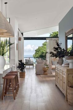 a living room filled with furniture next to a large open kitchen and dining room area