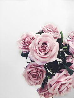 a bouquet of pink roses sitting on top of a table