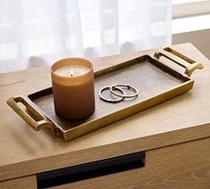 a candle and two wedding rings on a tray