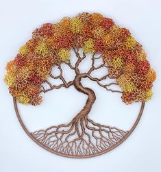 a metal tree with colorful leaves on it's branches and roots in the shape of a circle