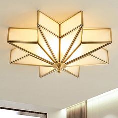 a ceiling light that is hanging from the ceiling in a room with white walls and flooring