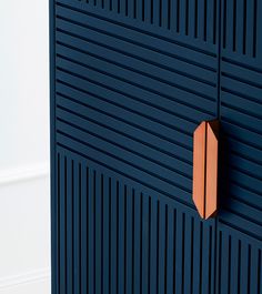 an orange object is mounted on the side of a blue wall with vertical slats