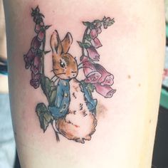 a small tattoo of a rabbit with flowers on it