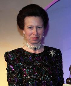 the woman is holding an award for her work in television and film, while wearing a black dress with sequins on it