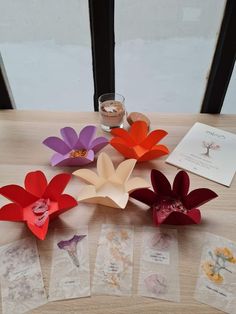 several paper flowers and cards on a table