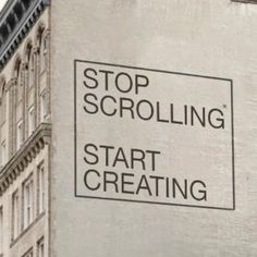 a sign on the side of a building that says stop scrolling start creating