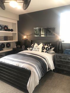 a bed sitting in a bedroom next to a dresser and lamp on top of it