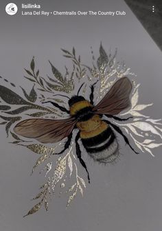 a close up of a bee on a white surface with silver leaves and plants around it