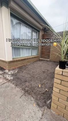 a house that has some dirt on the ground in front of it and there is a plant