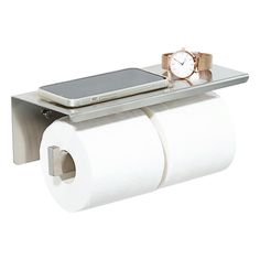 a cell phone is sitting on top of two rolls of toilet paper and a watch