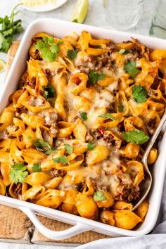 a casserole dish filled with pasta, meat and cheese topped with cilantro