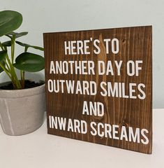 a wooden sign that says here's to another day of outward smiles and inward screams