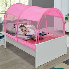 a child's bed with a pink canopy over it and a stuffed animal in the middle