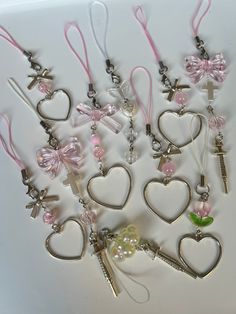 a bunch of key chains that are shaped like hearts with bows and keys attached to them