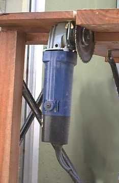 an electric driller sitting on top of a wooden table next to a window sill