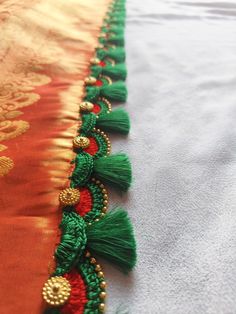 an orange and green table runner with tassels