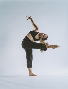 a woman in black shirt and pants doing a dance pose