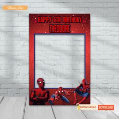 a spiderman photo frame with the words happy birthday theodore and two people sitting in front of it