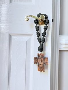 a door handle with a cross hanging from it's side and a sign that says, what is god?