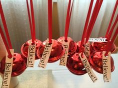 red candles with labels on them are sitting in a vase