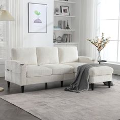 a white couch sitting on top of a rug in a living room next to a window