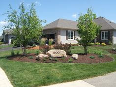 a house with landscaping and trees in the front yard