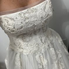 the back of a wedding dress with white lace on it and an off - shoulder top